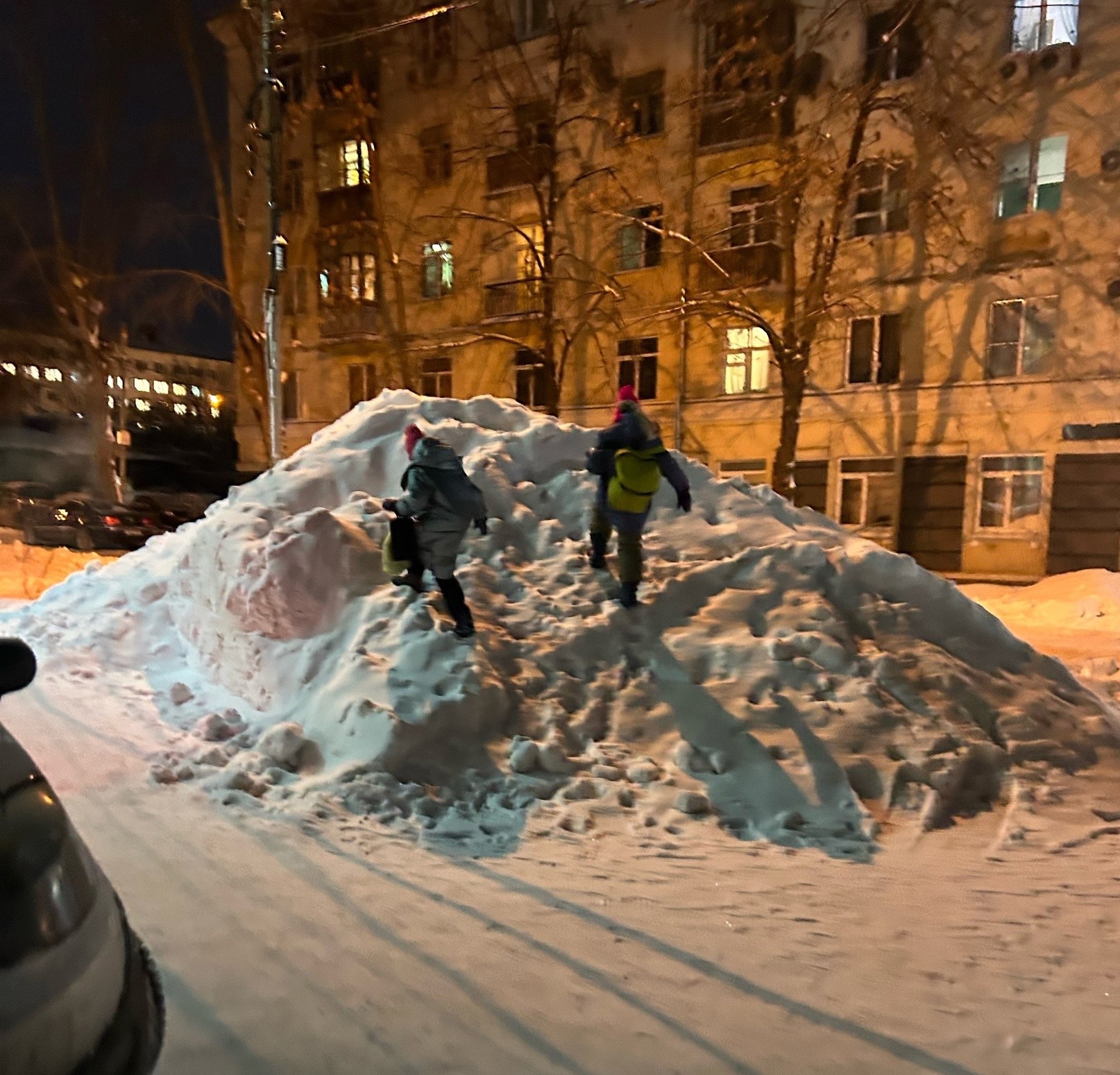 В центре Уфы работники РЖД навалили огромную кучу снега возле дороги. С «горки» начали кататься дети
